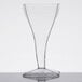 A clear Fineline Tiny Temptations square wine glass with a cone-shaped base on a table.