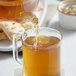 Davidson's Organic Tulsi Ginger Lemon Tea being poured into a glass.