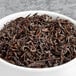 A bowl of Davidson's Organic Lapsang Souchong black loose leaves.
