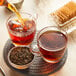 Loose leaf Davidson's Organic Earl Grey with Lavender tea being poured into a glass cup of tea.