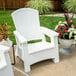 A white Suncast Adirondack chair on a patio with a potted plant and green leaves.