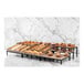 An Abert Revolution riser set with a tray of pastries on a counter.