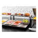 A black Abert Domino buffet podium with food on a table.