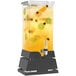 A Rosseto clear acrylic beverage dispenser with a black matte pyramid base filled with fruit and juice.