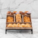 A display of pastries on a table using an Abert Revolution riser set with divided tray.