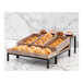 An Abert Revolution riser set with a divided tray of pastries on a marble counter.