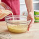 A person pouring California Farms Organic Evaporated Milk into a bowl.