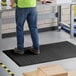 A man standing on a black Choice anti-fatigue floor mat.