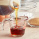 A person pouring Karo Dark Corn Syrup into a measuring cup.