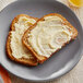 Two slices of toast with Earth Balance Vegan Buttery Spread on a plate.