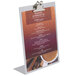 An aluminum Menu Solutions Alumitique menu tent with a clip holding a menu.