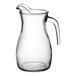 A clear glass pitcher with a handle.