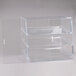 A clear plastic slanted front display case with three shelves.