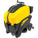 A yellow and black Tornado stand-on floor scrubber.