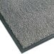 A close-up of a gunmetal grey Notrax carpet entrance mat with black edges.