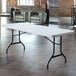 A white Lifetime folding table set in a room with chairs.