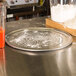 An American Metalcraft Super Perforated Heavy Weight Aluminum Pizza Pan with flour on it next to a bowl of flour and a blender.