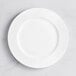 A white Acopa Cordelia porcelain plate with a wide rim and circular pattern.