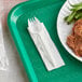 A white plastic spork and napkin on a tray.