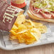 A tray with a sandwich and a bag of Kettle Brand Sea Salt potato chips.