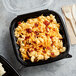 An 8" x 8" plastic hinged container of macaroni and cheese on a table.