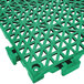 A green plastic Cactus Mat interlocking floor tile with holes.