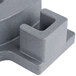 A navy blue plastic block with two holes on a table.