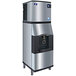 A close-up of a Manitowoc stainless steel touchless ice dispenser with black and silver details.