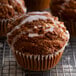 A White fluted baking cup with a muffin with white icing on top.