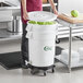 A woman holding a large white vegetable crisper bin full of lettuce.