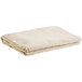 A stack of folded beige Monarch Brands canvas drop cloth runners.