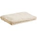 A folded beige canvas drop cloth on a white background.