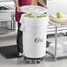 A woman using a white Choice Vegetable Crisper Bin to hold green cabbage.