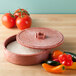 A red HS Inc. polyethylene tortilla server with food inside and an open lid on a table with tomatoes.