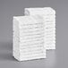 A stack of Lavex white cotton wash cloths.