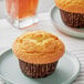 A David's Cookies corn muffin in a wrapper on a plate.