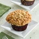 A David's Cookies Cinnamon Chip Muffin on a plate with a fork and napkin.