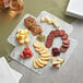 An Enjay marble laminated take-out box with meats and treats on a table.