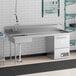 A Regency stainless steel dishtable with a right drainboard under a counter with a sink and dishwasher.
