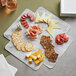 An Enjay marble laminated take-out box with a plate of meat and sausage.