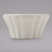 A Hall China ivory flared ramekin with wavy lines on the edge.