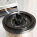 An ARY VacMaster vacuum canister with a vacuum tube in the lid.