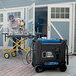 A man working on a DuroMax portable generator outside.