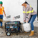 A woman and a man using a propane tank and gas can to fuel a DuroMax portable generator.