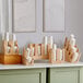 An Acopa Wood 2-section cup and lid organizer holding paper cups on a counter.