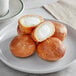 A white plate with Poppy's Stuffed Plain Bagel Holes on it.