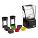 A Blendtec Stealth Nitro X blender with different colored bowls and lids.