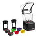 A black and clear Blendtec Stealth Nitro Blender on a counter with different colored bowls and lids.