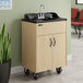 A portable hot water hand sink with a maple laminate cabinet, single basin, and wheels for mobility.