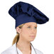 A woman wearing a navy blue Intedge chef hat.